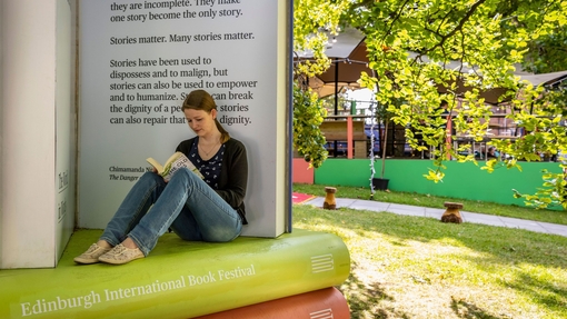 Sitzende Frau beim Lesen auf einem Buchfestival