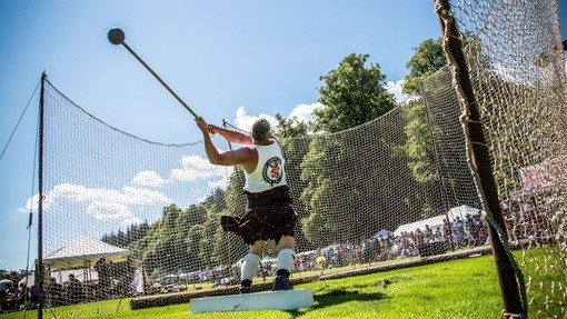 Inveraray Argyll Highland Games at Inveraray Castle. Man wearing a kilt doing the hammer throw.