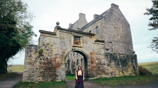 A woman walks in front of an heritage castle