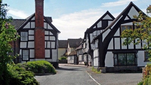 View of street lined with black and white timber framed cottages