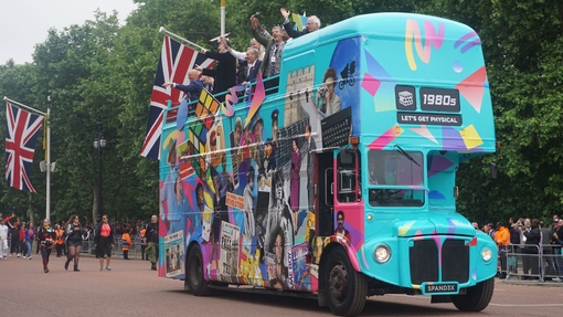 Bild eines blauen Reisebusses mit Union-Jack-Flaggen