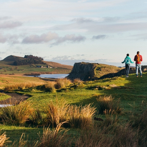 Two young adults walking the Northumberland, UK countryside.