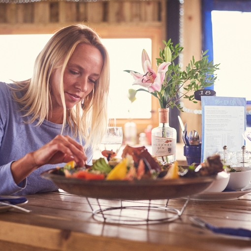 Blond woman and man sitting at table, eating seafood platter