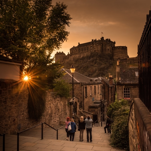 Pedestrians walking down steps near a castle