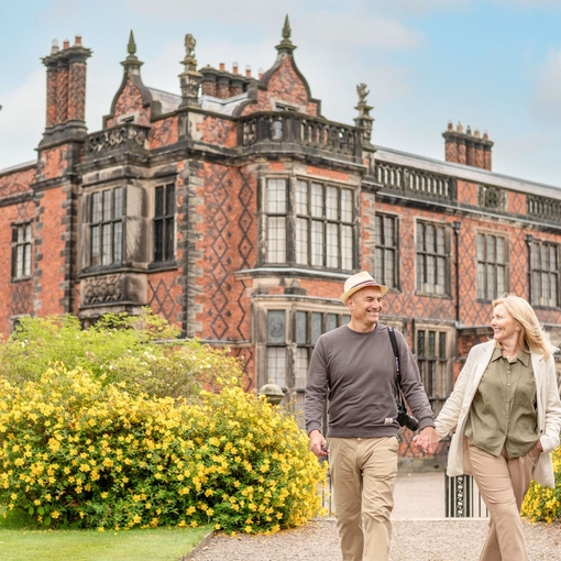 A man and a woman walk through the grounds of a heritage property