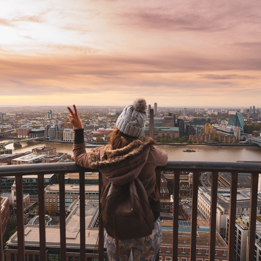 Woman at the top of St Paul's dome at sunrise with city view