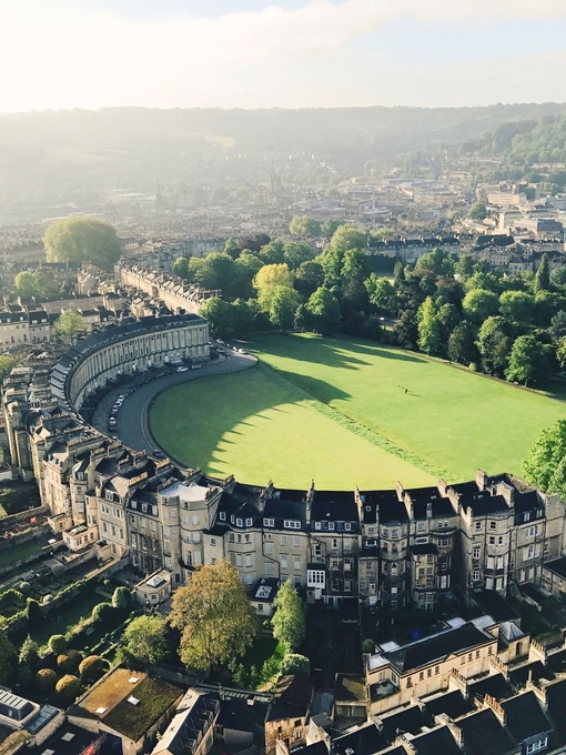 Luftaufnahme eines sichelförmigen, von Gras umgebenen Gebäudes