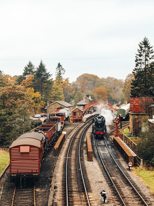 Steam train on train tracks and old-fashioned carriages at Goathland Railway Station