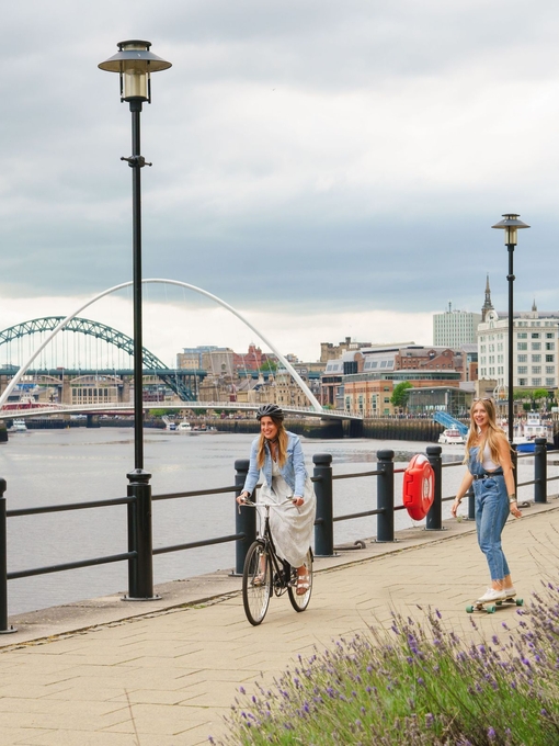 Two men skateboard along the River Tyne in Newcastle