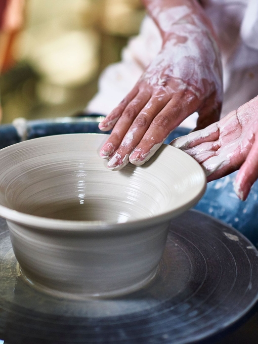 Woman making pottery, Potter's hands making bowl on pottery wheel