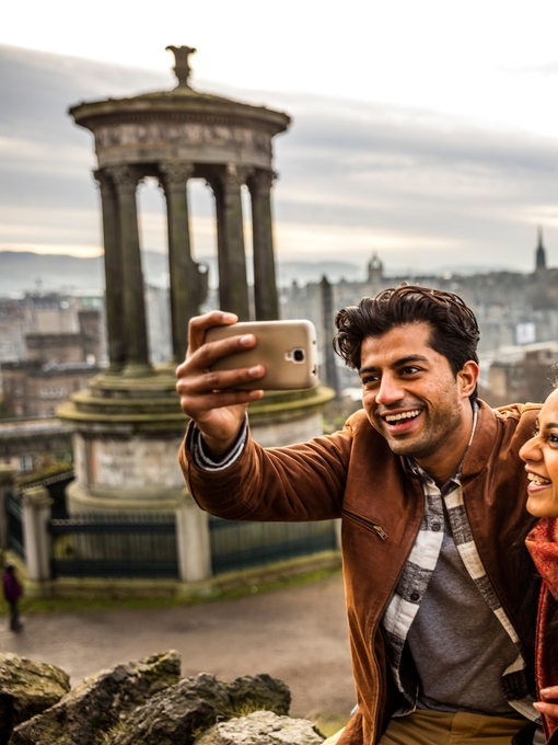 A young couple taking a selfie of view over historic town