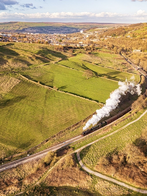 Steam train travelling along tracks in the countryside