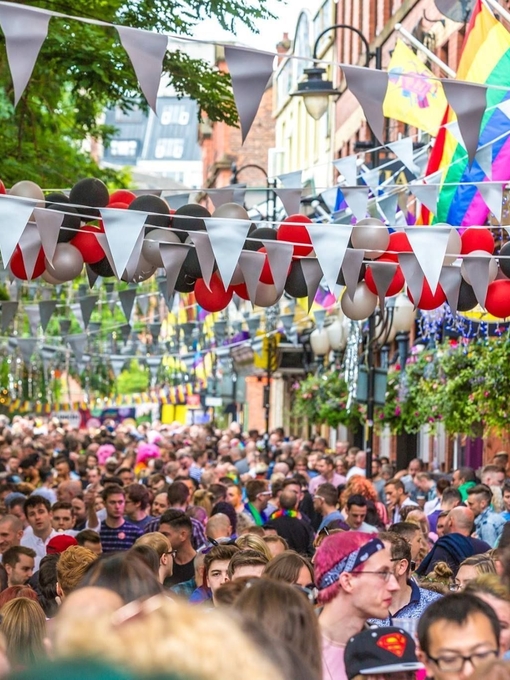 Crowds of people walking along Manchester's Canal Street