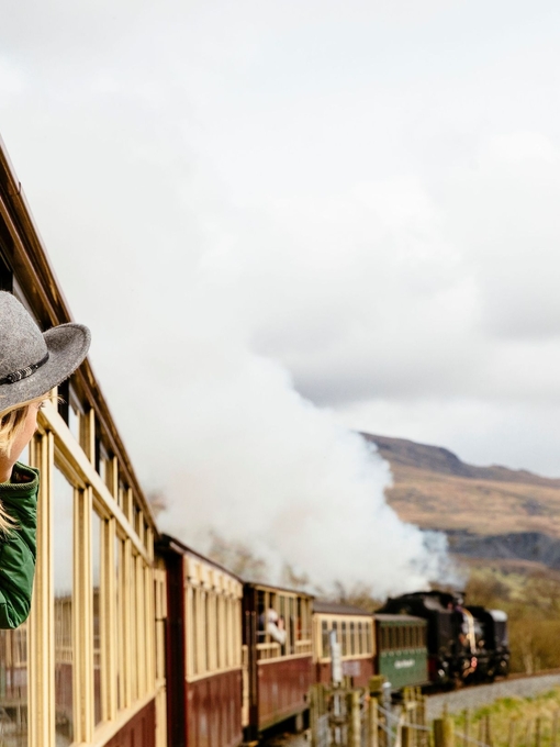Woman looking out of window of traditional railway train