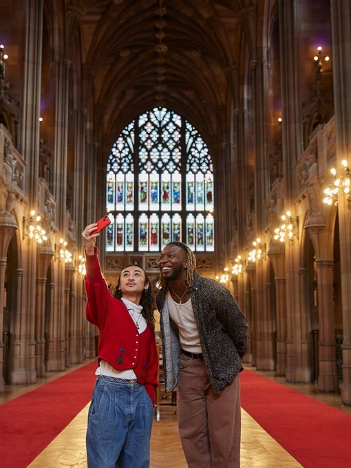 رجلان يلتقطان صورة سيلفي داخل مكتبة كبيرة.