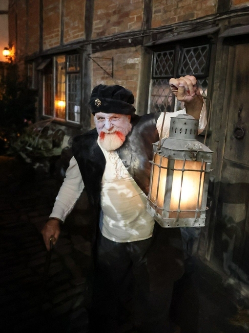 Ein Mann hält eine Laterne im Tudor World Museum