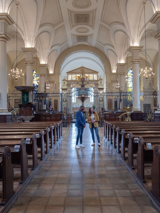 Two people standing inside a cathedral
