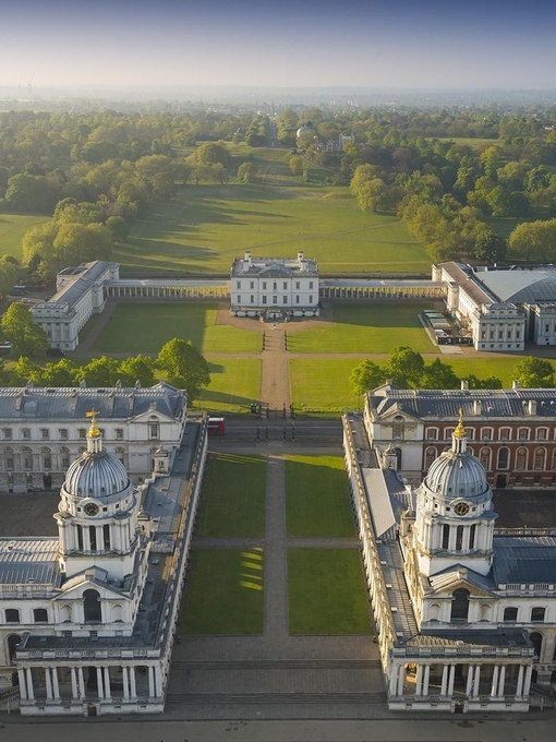Aerial view of a massive mansion and manicured gardens.
