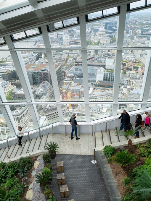 People walking down the stairs Sky Garden wth the city in the background