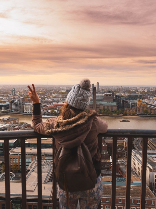 Woman at the top of St Paul's dome at sunrise with city view