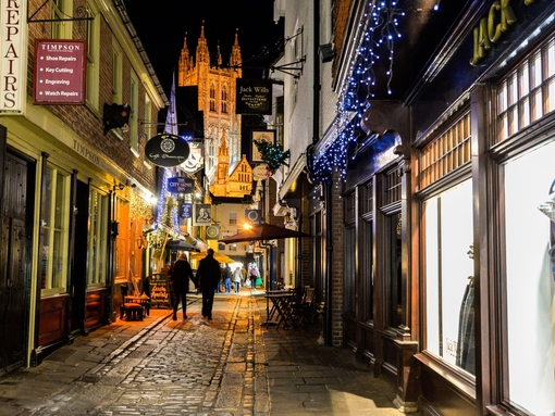Man and woman walking along a street at night