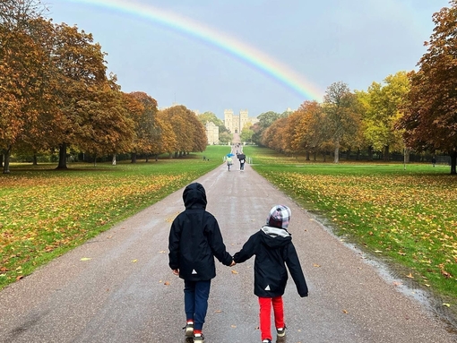 A couple walking towards Windsor Castle on the Long Walk in the Great Park