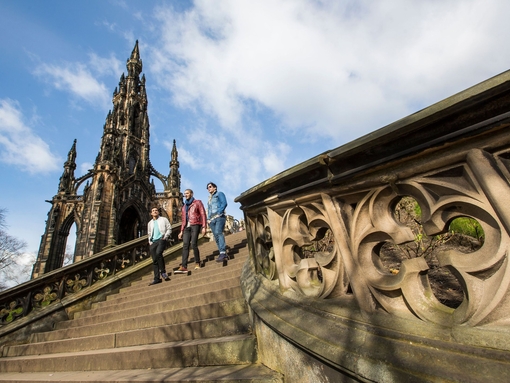 Three men walking down stone steps of a monument
