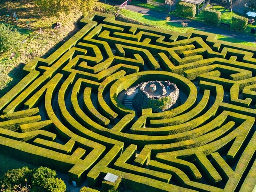 Aerial view of woman walking up the central tower of a hedge maze