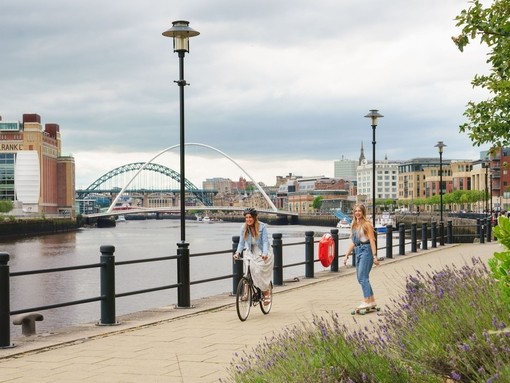 Two men skateboard along the River Tyne in Newcastle