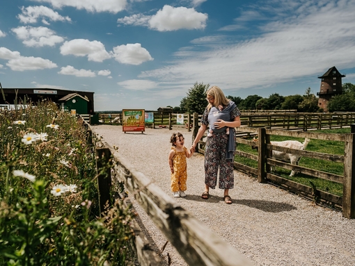 A woman and a child walk through an animal farm attraction