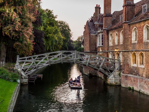 A single punt passes under the Mathematical bridge, in Silver street, Cambridge late on a summer's evening