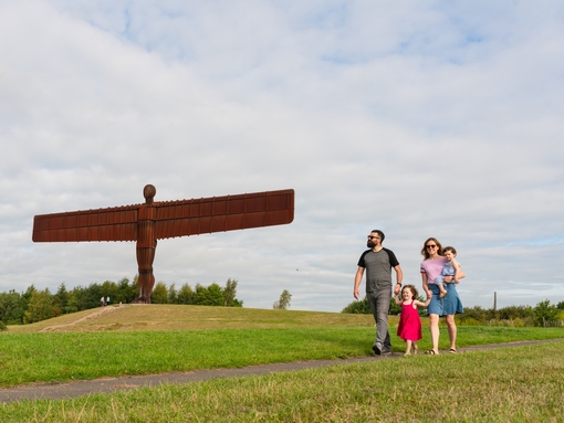 A family walking in front of the iconic Angel of the North, found just south of Newcastle Gateshead