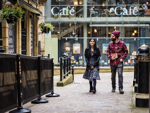 A woman and a man walk through a town centre