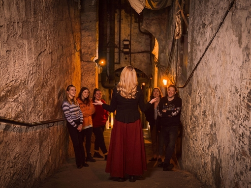 A tour guide leading a tour through the Real Mary King's Close in Edinburgh, Scotland