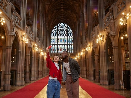 رجلان يلتقطان صورة سيلفي داخل مكتبة كبيرة.