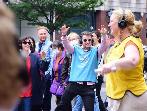 A group of people on an outdoor Silent Disco in London's West End