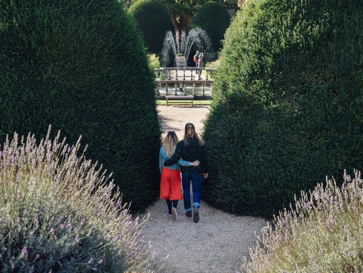 Male and female couple hugging in a garden near a fountain
