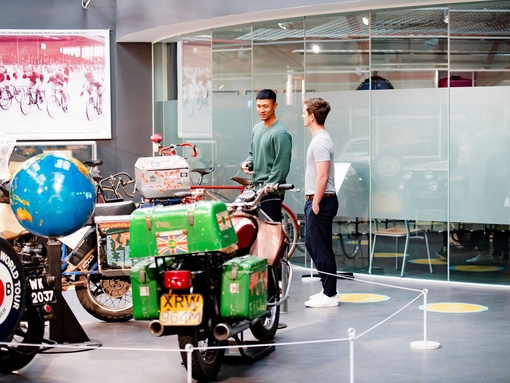 Two men looking at an exhibit of motorbikes at Coventry Transport Museum.