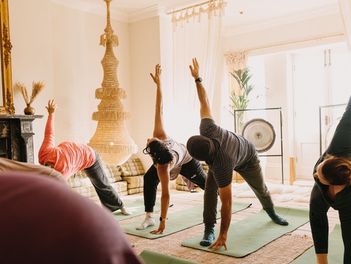 Four people practise yoga on mats during a wellness retreat