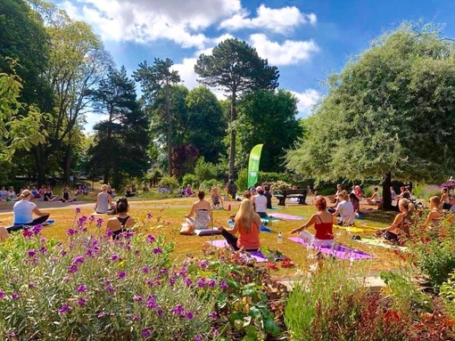 Groups of people taking a yoga session in a park on the Jurassic Coast