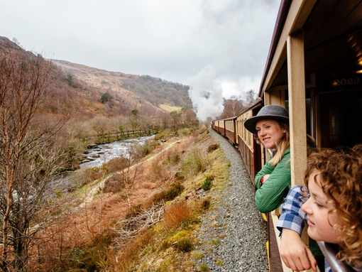 Woman and boy leaning out of window of steam train