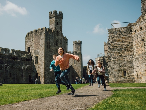 Kids running through the grounds of an old castle.