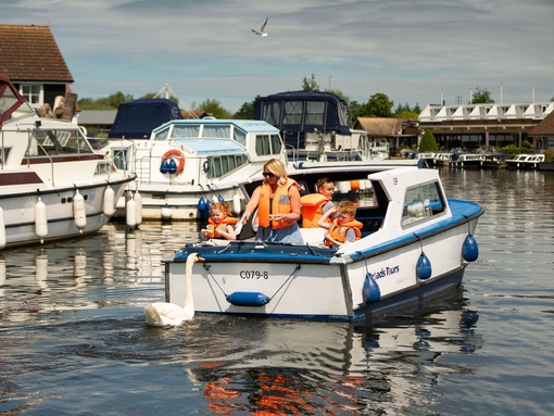 A family riding on a boat in the Norfolk Broads