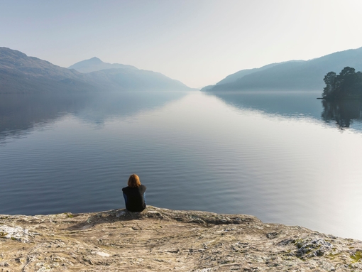 Une femme assise regardant le Loch Lomond, Écosse
