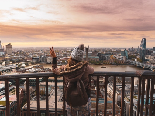 Woman at the top of St Paul's dome at sunrise with city view
