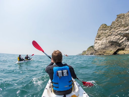 People kayaking along the shores of coastline