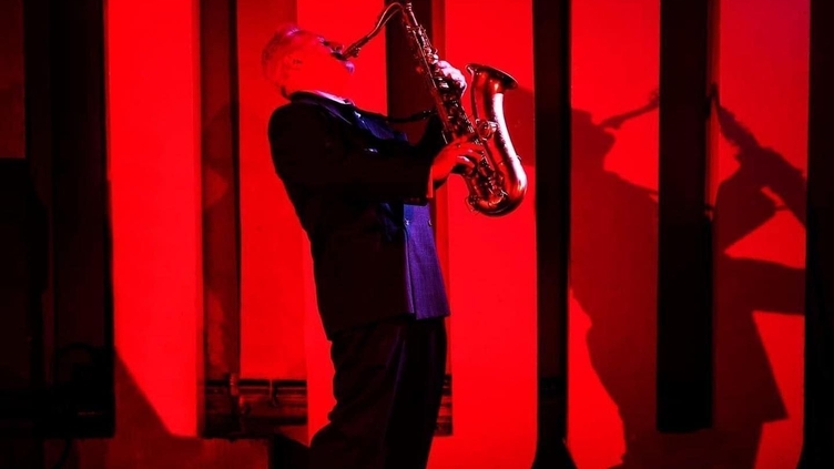 Ein Mann spielt Saxophon auf der Bühne