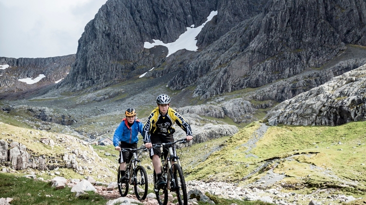 Two mountain bikers cycling downhill down a mountain