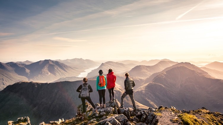 People standing on high point looking down at mountain view