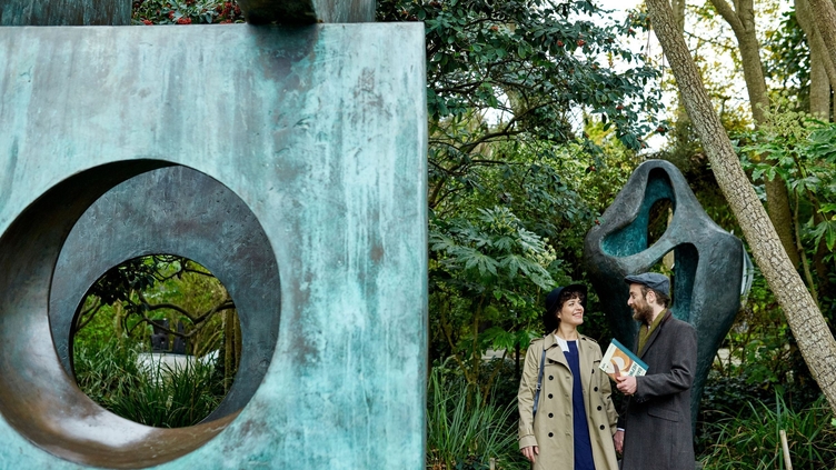A couple examining the sculptures and bronze installations